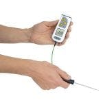 White TempTest 2 Thermometer being held upside down, with penetration probe and digital display.